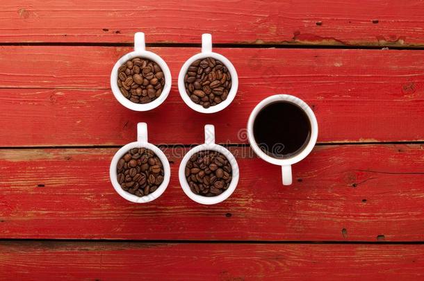 咖啡豆.咖啡豆杯子和咖啡豆豆向红色的木制的背景.