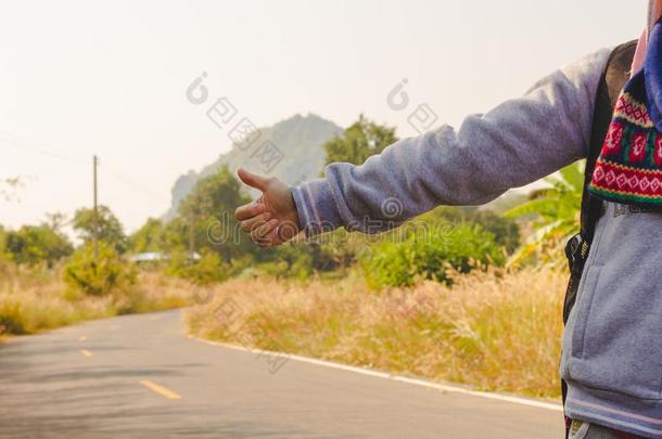 女人起立在近处路道路和手自动停车户外的