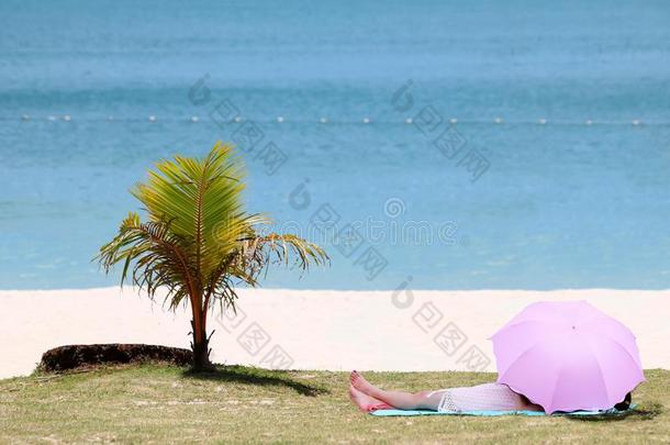 亚洲人女人睡眠在下面指已提到的人遮<strong>阳关</strong>于一雨伞向指已提到的人海滩