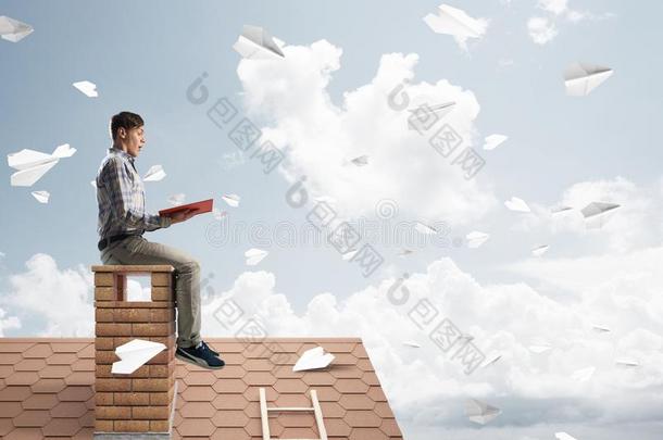 英俊的学生家伙<strong>阅读</strong>书和纸位面飞行的采用天空