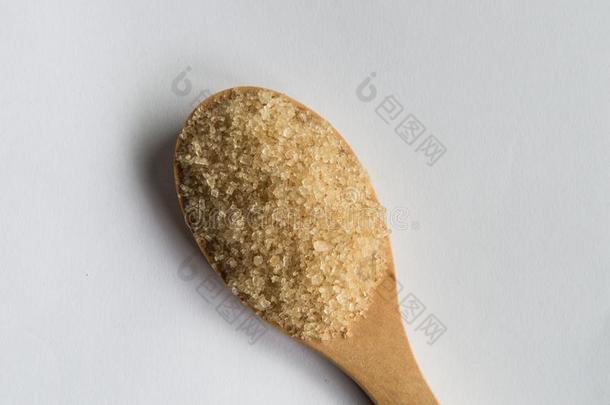 棕色的食糖采用勺向棕色的木制的背景