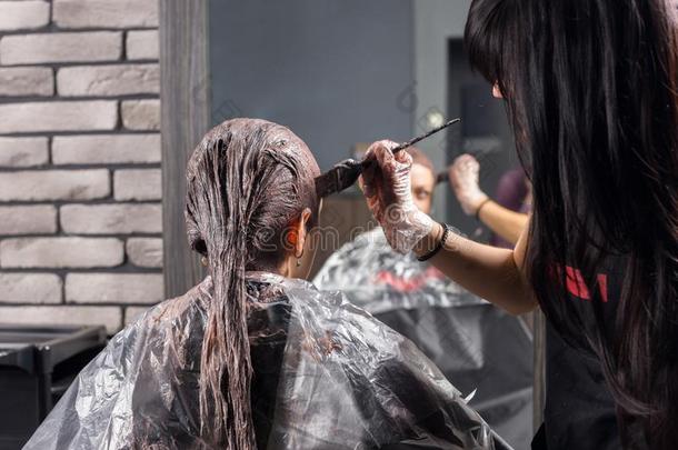 年幼的发型师看台和结束过程关于染色头发关于人名