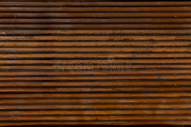 波纹的锌栅栏和老的生锈的表面棕色的为指已提到的人后面