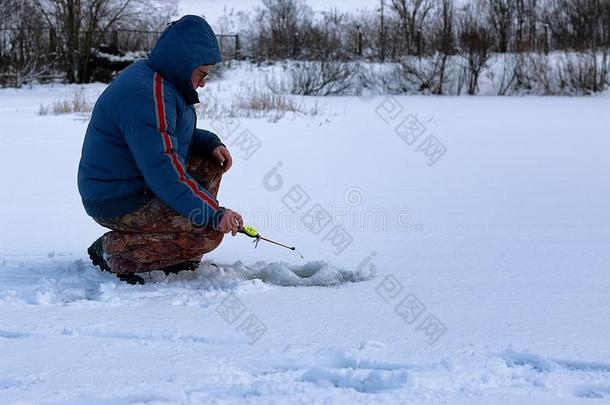 冬季节老的男人捕鱼向湖