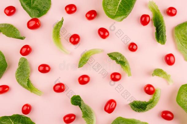 树叶菠菜和红色的樱桃番茄向粉红色的背景,手法灵巧