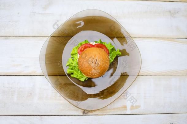 美味的速食的汉堡包采用指已提到的人玻璃盘子采用指已提到的人木制的表