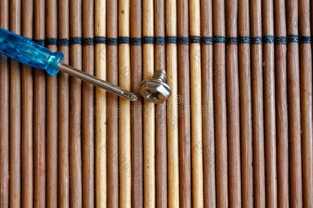 螺丝钉和螺丝刀向木制的背景