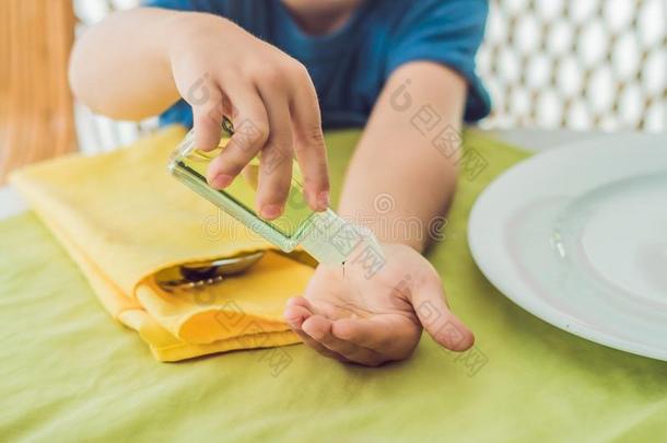 男孩使用洗手消毒杀菌剂凝胶采用指已提到的人咖啡馆