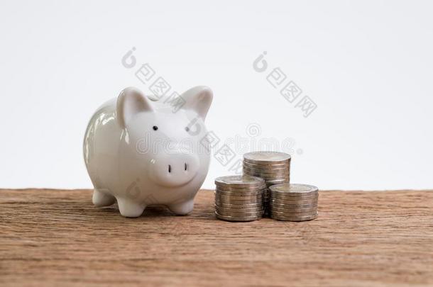 白色的小猪银行和coinsurance联合保险堆积向表和白色的背景
