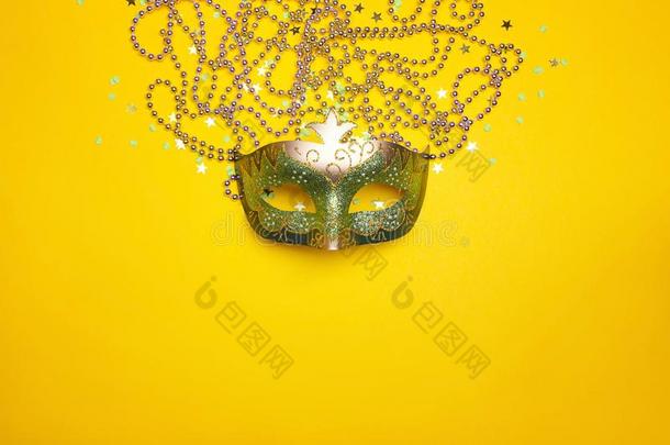 节日的狂欢节面具和小珠子向一黄色的b一ckground.