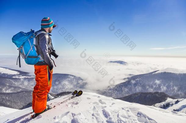 年幼的积极的男人赞赏的指已提到的人山谷看法从一背脊在期间滑雪