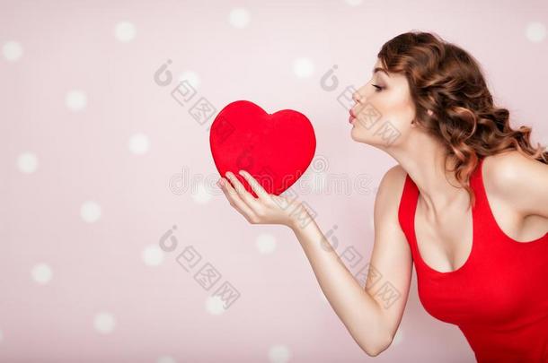 女人和红色的心向粉红色的背景.