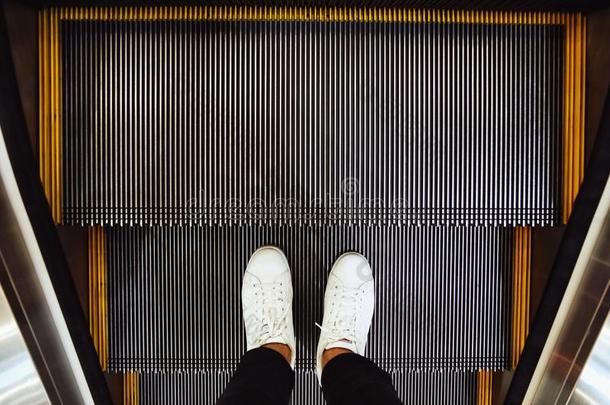 自拍照关于男人脚采用白色的橡皮底帆布鞋鞋子向自动扶梯级别采用