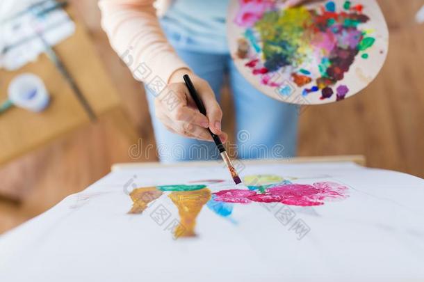 艺术家和调色板和刷子绘画在工作室