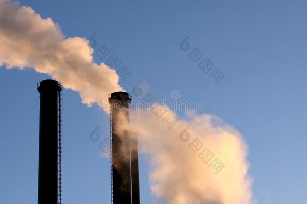 云关于白色的烟从工业的烟囱反对蓝色清楚的