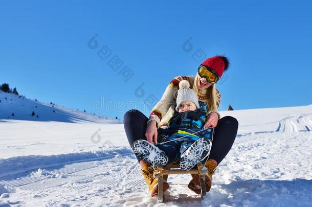 照片关于幸福的母亲和小孩演奏采用指已提到的人雪和一雪橇