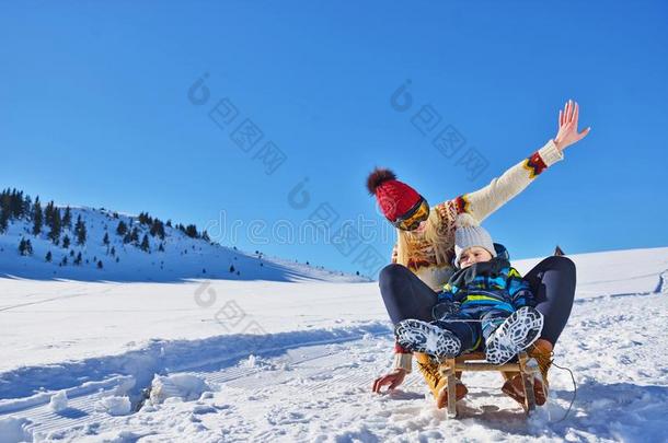 照片关于幸福的母亲和小孩演奏采用指已提到的人雪和一雪橇