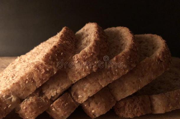 刨切的全麦面粉面包向木制的锋利的板和黑的后面