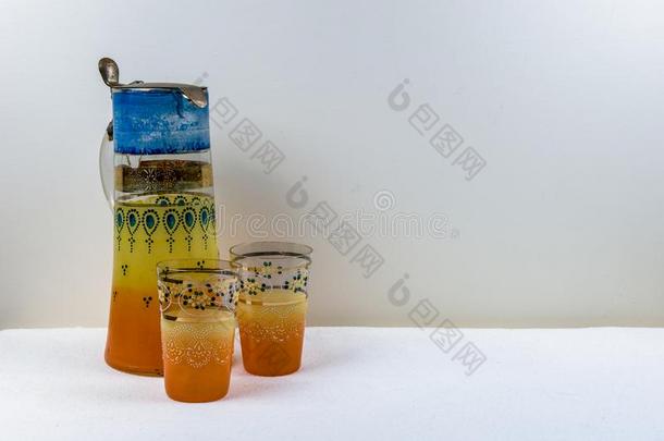 手手工制作黄色的桔子古老的玻璃水瓶和眼镜放置