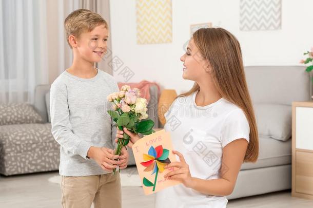 年幼的女人接受花和卡片从她小的儿子家