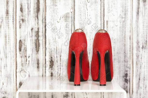 指已提到的人一副关于美丽的猩红色红色的高的拖鞋向一白色的木制的