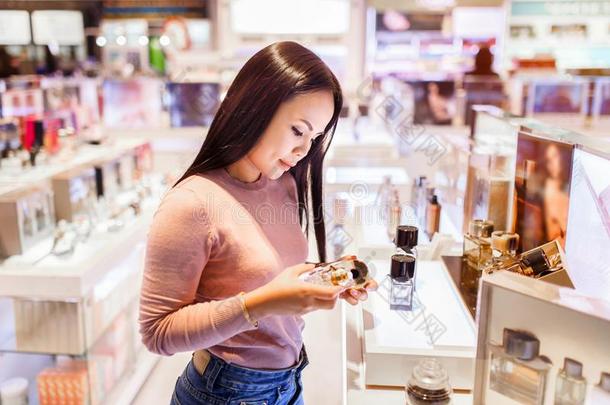 年幼的亚洲人女人应用和挑选向购买香水采用<strong>职责</strong>倍频器