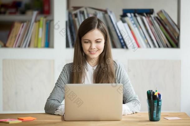 微笑的女孩使用便携式电脑,学生学习在家,数字的Educationalinstitutions教研机构