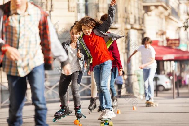 幸福的青少年滑板运动和朋友在面走