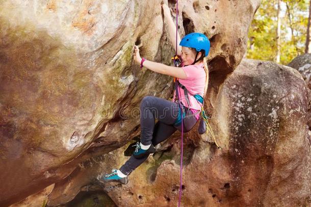 幸福的十几岁的女孩岩石攀登的采用森林地区