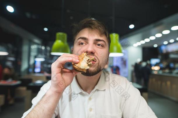 一饥饿的男人享有一熟食店汉堡包一t一f一st食物rest一ur一nt.