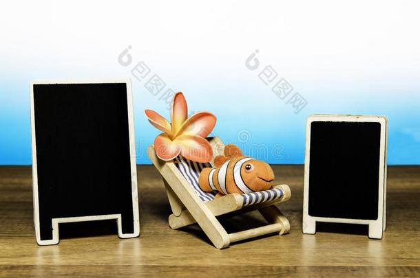丑角鱼向海滩床和花和两个空白的背板