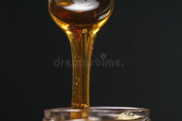 捞球有机的蜂蜜和勺从玻璃罐子