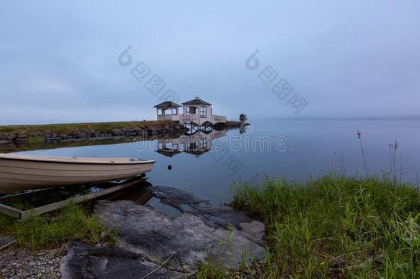 有雾的早晨向指已提到的人湖和小船向前景