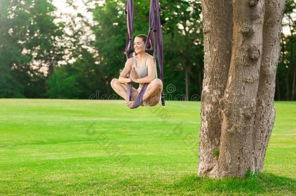 年幼的女人<strong>开业</strong>的空气的瑜伽向树