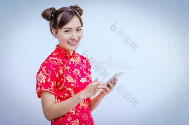 亚洲人女人和旗袍佃户租种的土地智能手机.