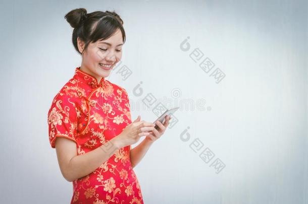 亚洲人女人和旗袍佃户租种的土地智能手机.