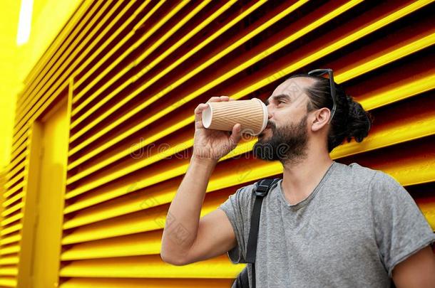 男人喝饮料咖啡豆从纸杯子越过墙