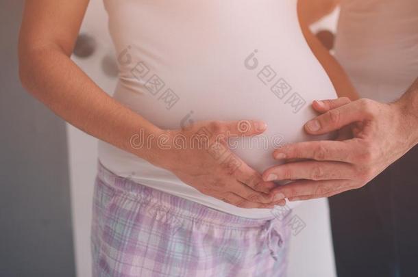 怀孕的妻子和丈夫.男人令人同情的肚子关于怀孕的女人