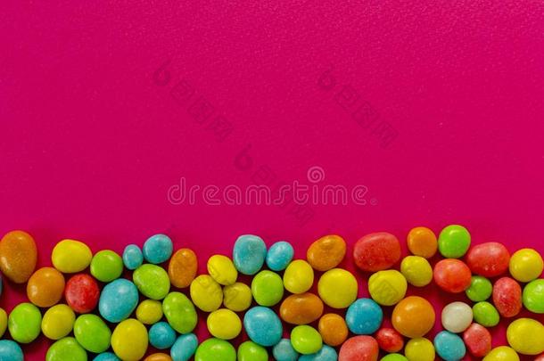 多彩的糖果向粉红色的背景和空间为文本