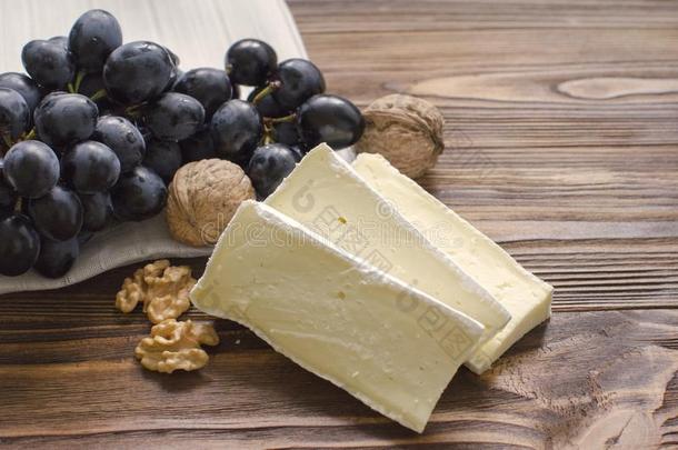 法国布里白乳酪奶酪和发疯的和葡萄向木制的背景