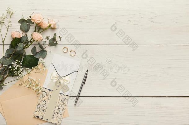 婚礼招待卡和信封向白色的木制的表,向