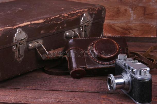 旅行观念和酿酒的手提箱老的照相机向木制的地面.