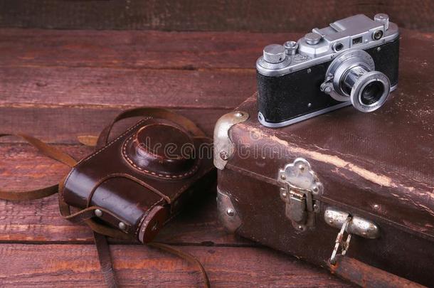 旅行观念和酿酒的手提箱老的照相机向木制的地面.