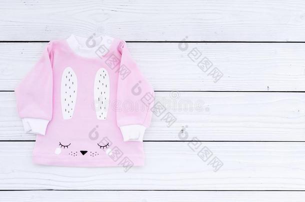 粉红色的婴儿衣服为小的女孩向白色的木制的背景顶