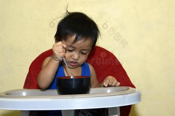 num.一1年老的亚洲人婴儿男孩学问向吃在旁边他自己,凌乱的