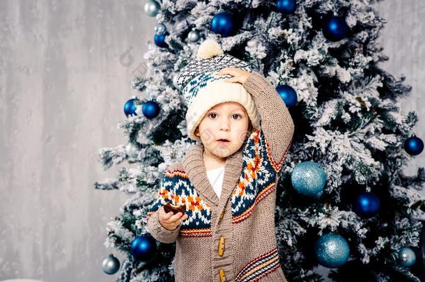 小的有趣的男孩采用饰头巾和身体羊毛制的毛衣食物巧克力