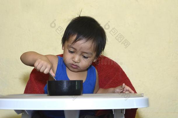 num.一1年老的亚洲人婴儿男孩学问向吃在旁边他自己,凌乱的