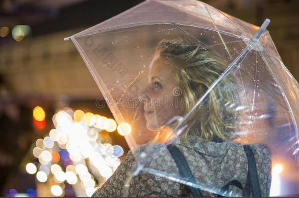 亚麻色的女人迷人的遮盖在下面她雨伞