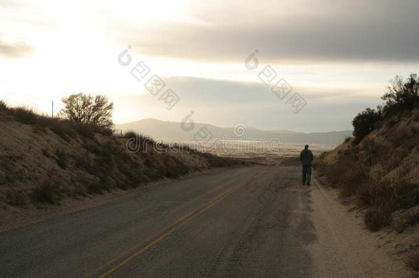 孤单的男人步态向空的公路.