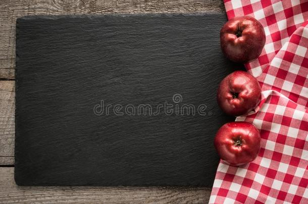 成熟的红色的苹果向木制的板和红色的checke红色的餐巾大约